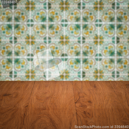 Image of Wood table top and blur vintage ceramic tile pattern wall
