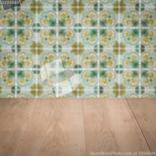 Image of Wood table top and blur vintage ceramic tile pattern wall