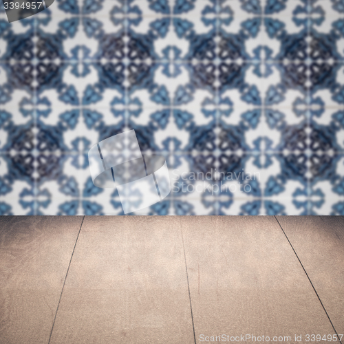 Image of Wood table top and blur vintage ceramic tile pattern wall