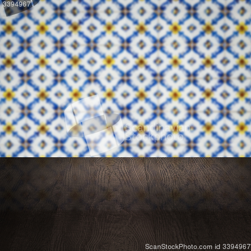 Image of Wood table top and blur vintage ceramic tile pattern wall