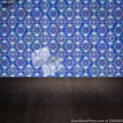 Image of Wood table top and blur vintage ceramic tile pattern wall