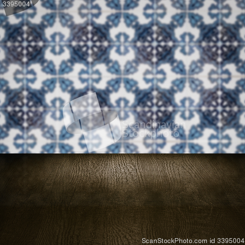 Image of Wood table top and blur vintage ceramic tile pattern wall
