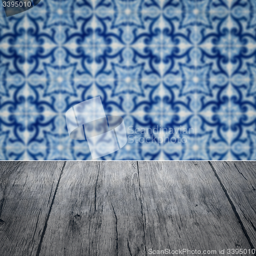 Image of Wood table top and blur vintage ceramic tile pattern wall