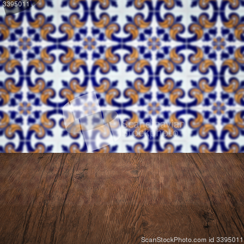 Image of Wood table top and blur vintage ceramic tile pattern wall