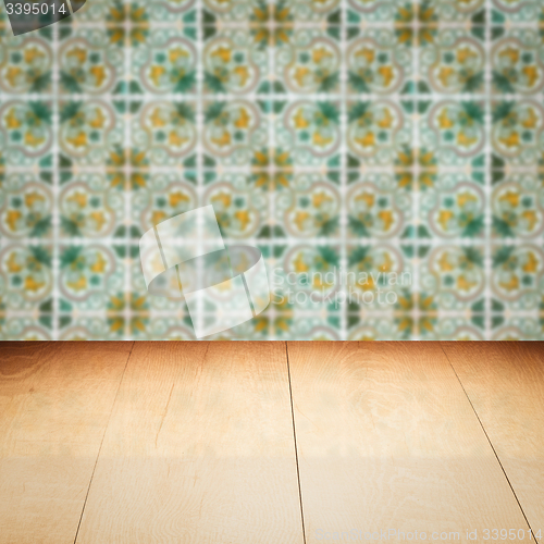 Image of Wood table top and blur vintage ceramic tile pattern wall