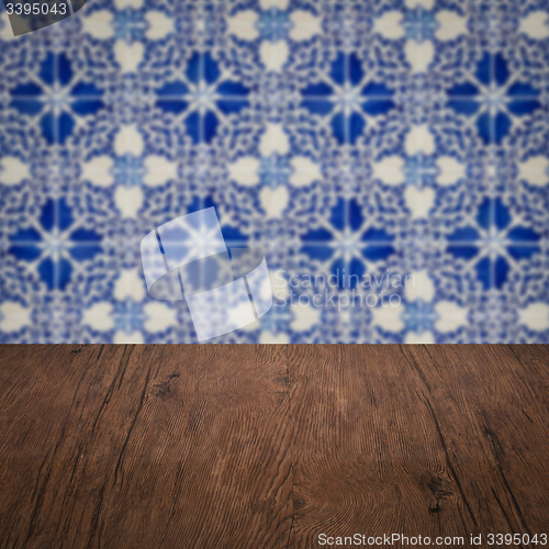 Image of Wood table top and blur vintage ceramic tile pattern wall
