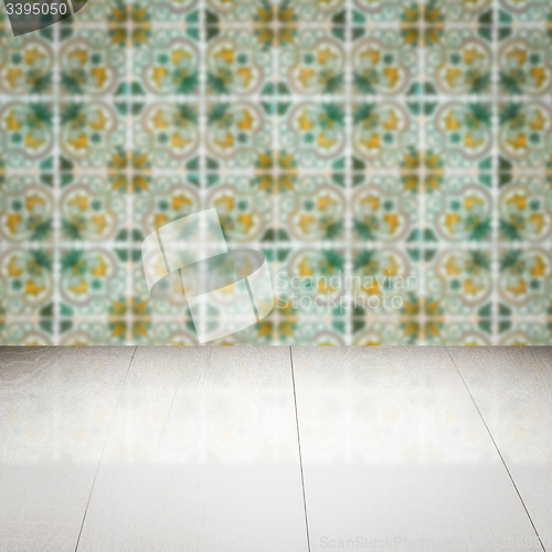 Image of Wood table top and blur vintage ceramic tile pattern wall
