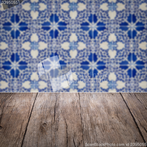 Image of Wood table top and blur vintage ceramic tile pattern wall