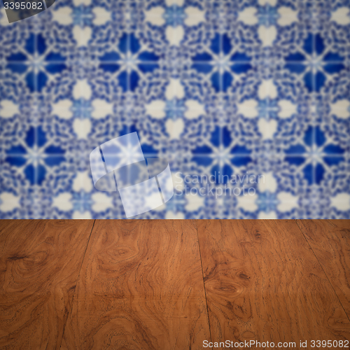 Image of Wood table top and blur vintage ceramic tile pattern wall