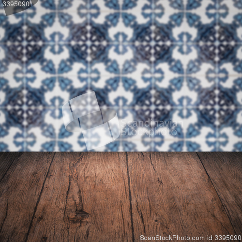Image of Wood table top and blur vintage ceramic tile pattern wall