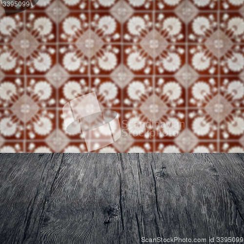 Image of Wood table top and blur vintage ceramic tile pattern wall