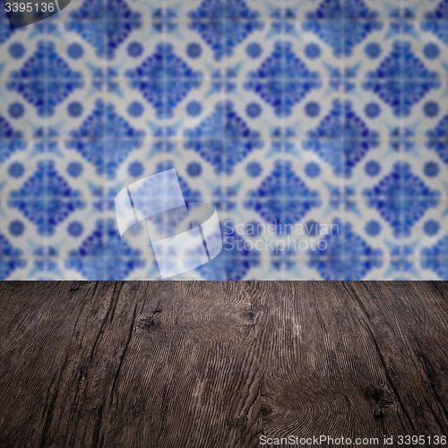 Image of Wood table top and blur vintage ceramic tile pattern wall