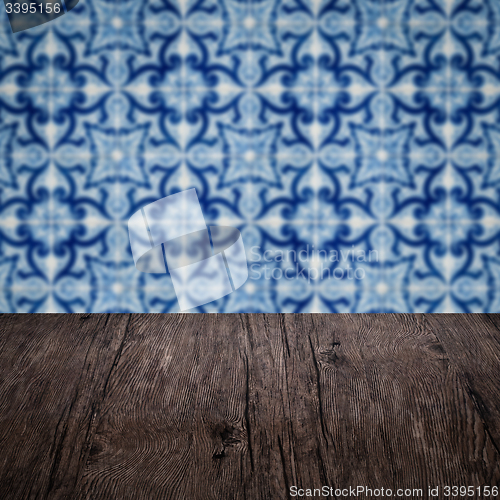 Image of Wood table top and blur vintage ceramic tile pattern wall