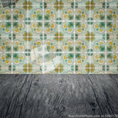 Image of Wood table top and blur vintage ceramic tile pattern wall