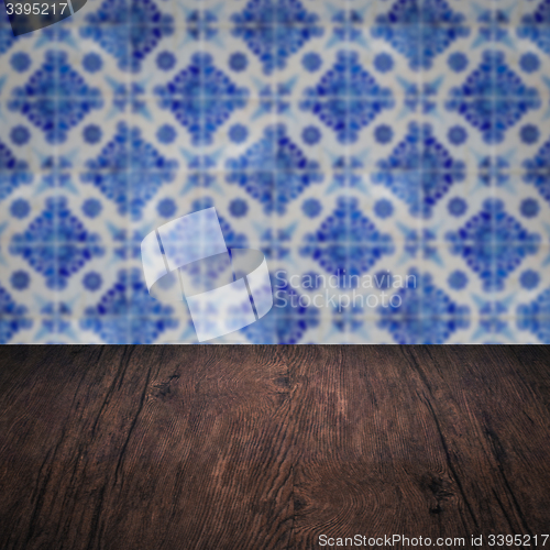 Image of Wood table top and blur vintage ceramic tile pattern wall