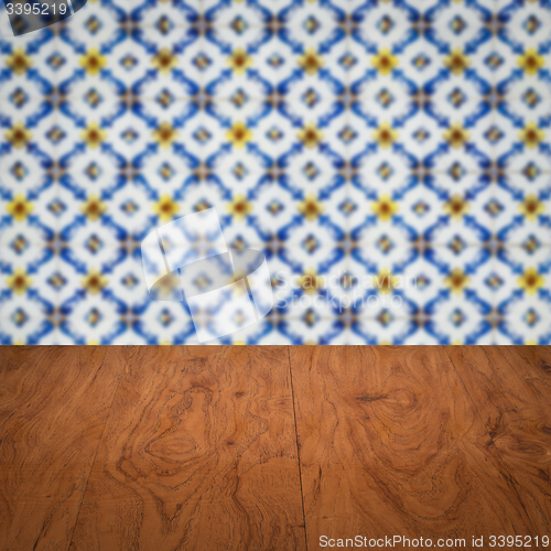 Image of Wood table top and blur vintage ceramic tile pattern wall