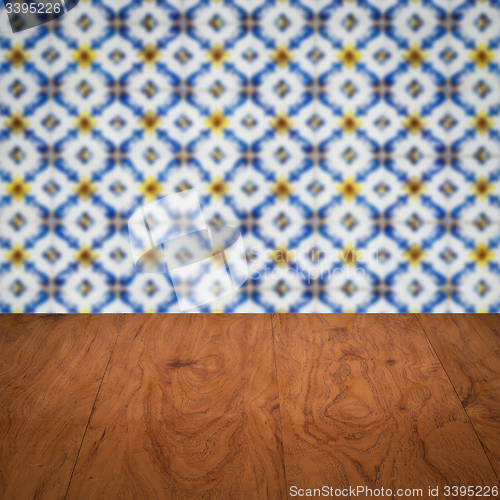 Image of Wood table top and blur vintage ceramic tile pattern wall