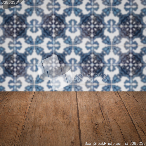 Image of Wood table top and blur vintage ceramic tile pattern wall