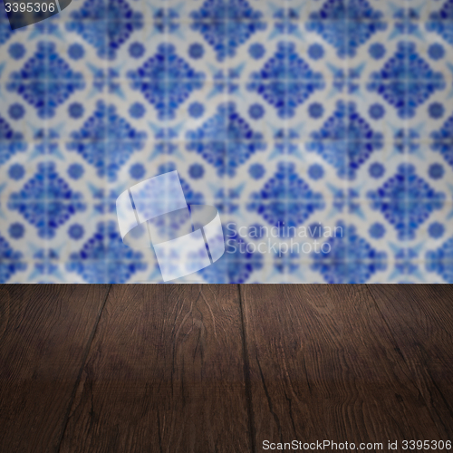 Image of Wood table top and blur vintage ceramic tile pattern wall