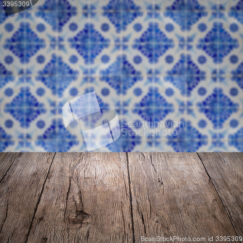 Image of Wood table top and blur vintage ceramic tile pattern wall