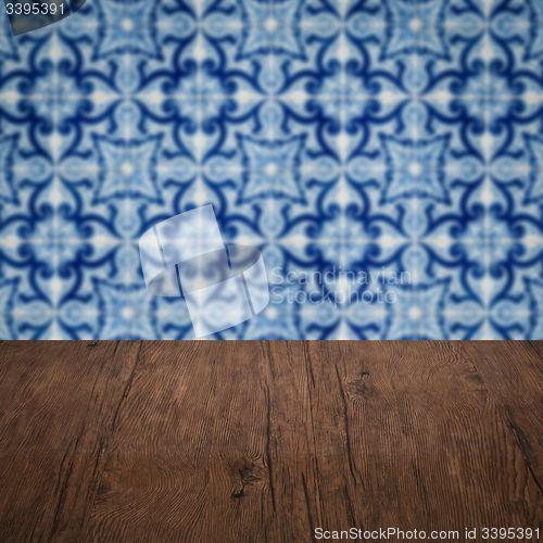Image of Wood table top and blur vintage ceramic tile pattern wall