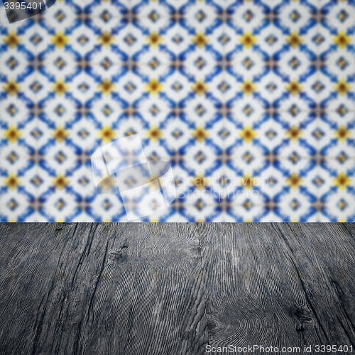 Image of Wood table top and blur vintage ceramic tile pattern wall