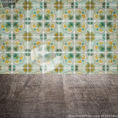 Image of Wood table top and blur vintage ceramic tile pattern wall