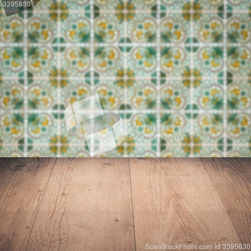 Image of Wood table top and blur vintage ceramic tile pattern wall