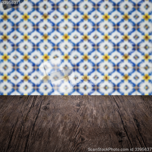 Image of Wood table top and blur vintage ceramic tile pattern wall