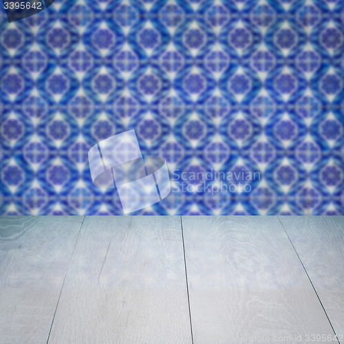 Image of Wood table top and blur vintage ceramic tile pattern wall