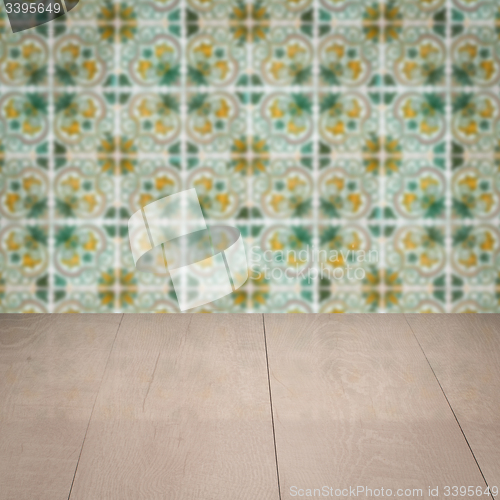 Image of Wood table top and blur vintage ceramic tile pattern wall