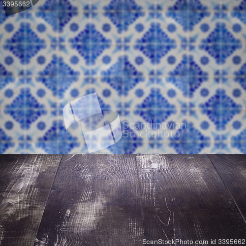 Image of Wood table top and blur vintage ceramic tile pattern wall