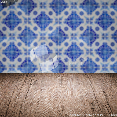 Image of Wood table top and blur vintage ceramic tile pattern wall