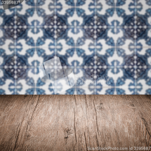 Image of Wood table top and blur vintage ceramic tile pattern wall