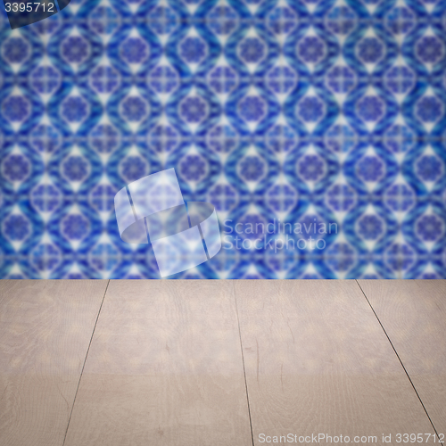 Image of Wood table top and blur vintage ceramic tile pattern wall