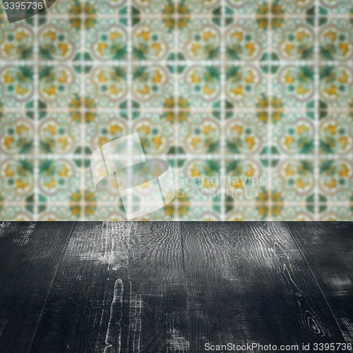 Image of Wood table top and blur vintage ceramic tile pattern wall
