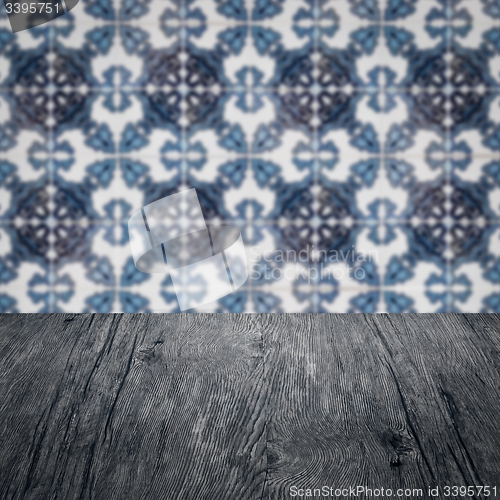 Image of Wood table top and blur vintage ceramic tile pattern wall