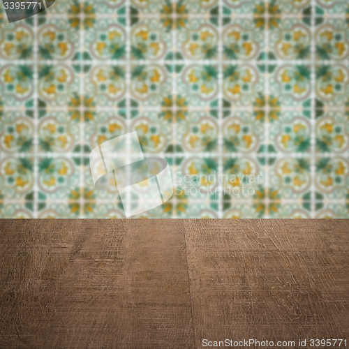 Image of Wood table top and blur vintage ceramic tile pattern wall