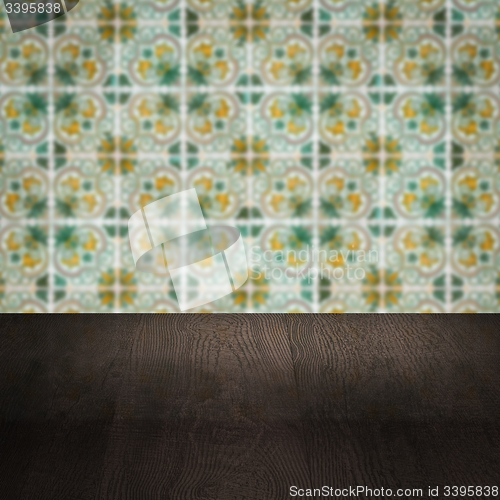 Image of Wood table top and blur vintage ceramic tile pattern wall