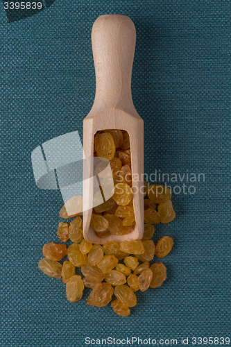 Image of Wooden scoop with golden raisins