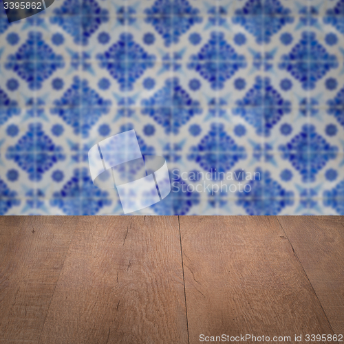 Image of Wood table top and blur vintage ceramic tile pattern wall