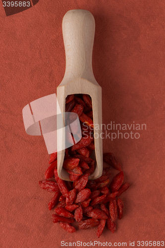 Image of Wooden scoop with dry red goji berries