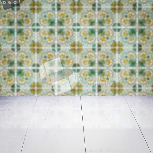 Image of Wood table top and blur vintage ceramic tile pattern wall
