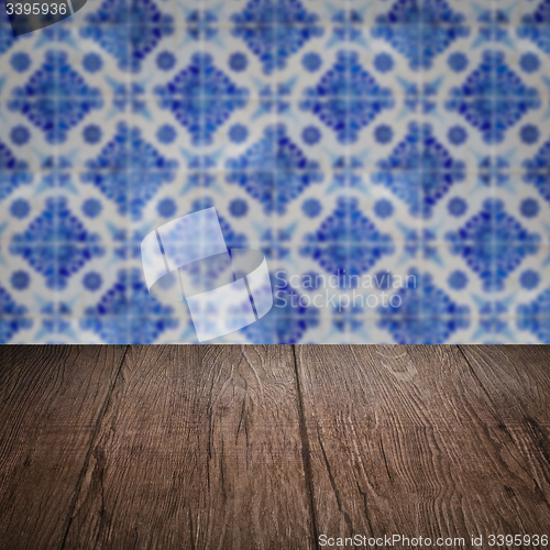 Image of Wood table top and blur vintage ceramic tile pattern wall