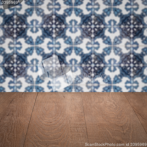 Image of Wood table top and blur vintage ceramic tile pattern wall