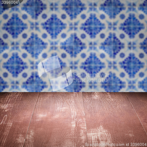 Image of Wood table top and blur vintage ceramic tile pattern wall