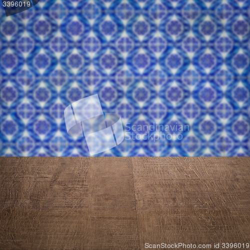 Image of Wood table top and blur vintage ceramic tile pattern wall