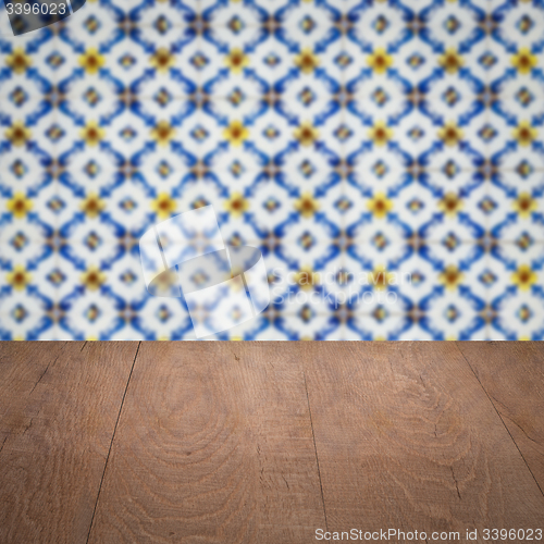 Image of Wood table top and blur vintage ceramic tile pattern wall