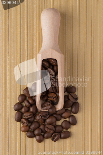 Image of Wooden scoop with coffee beans