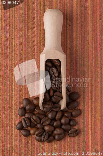 Image of Wooden scoop with coffee beans